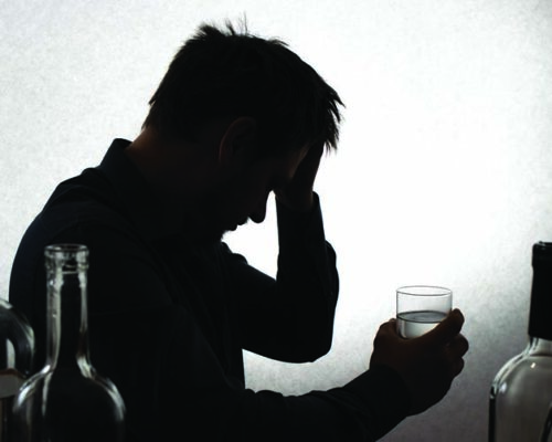 A man and a glass of vodka. Alcoholism, alcohol addiction, delirium tremens.